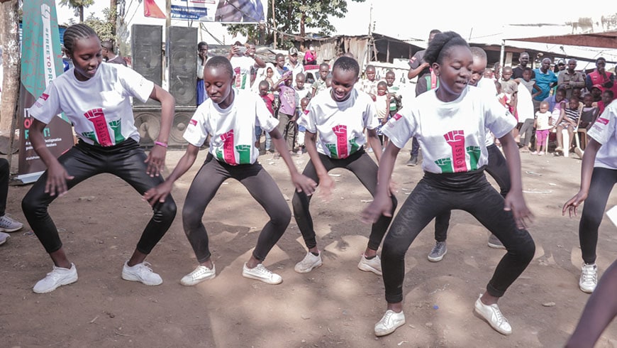 Four girls in Kenya dancing wearing free to protest t shirts