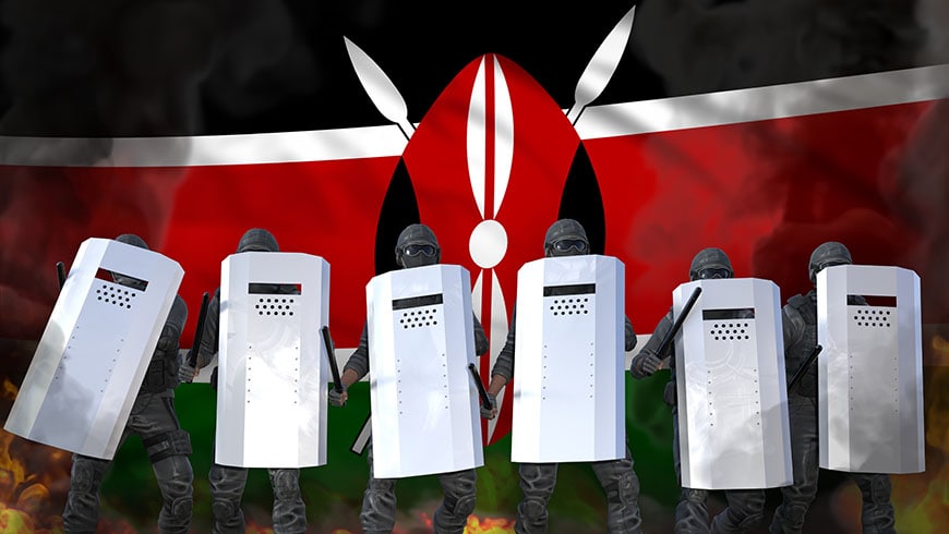 A barricade of police with shields with the Kenyan flag in the background