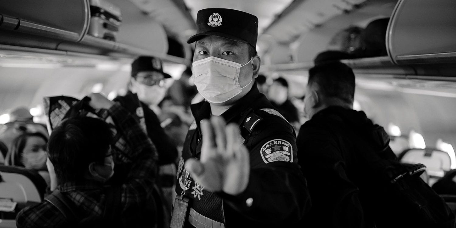 A policeman orders Reuters journalists off an airplane without explanation while the plane is parked on the tarmac at Urumqi airport, Xinjiang Uyghur Autonomous Region, China, 5 May 2021.