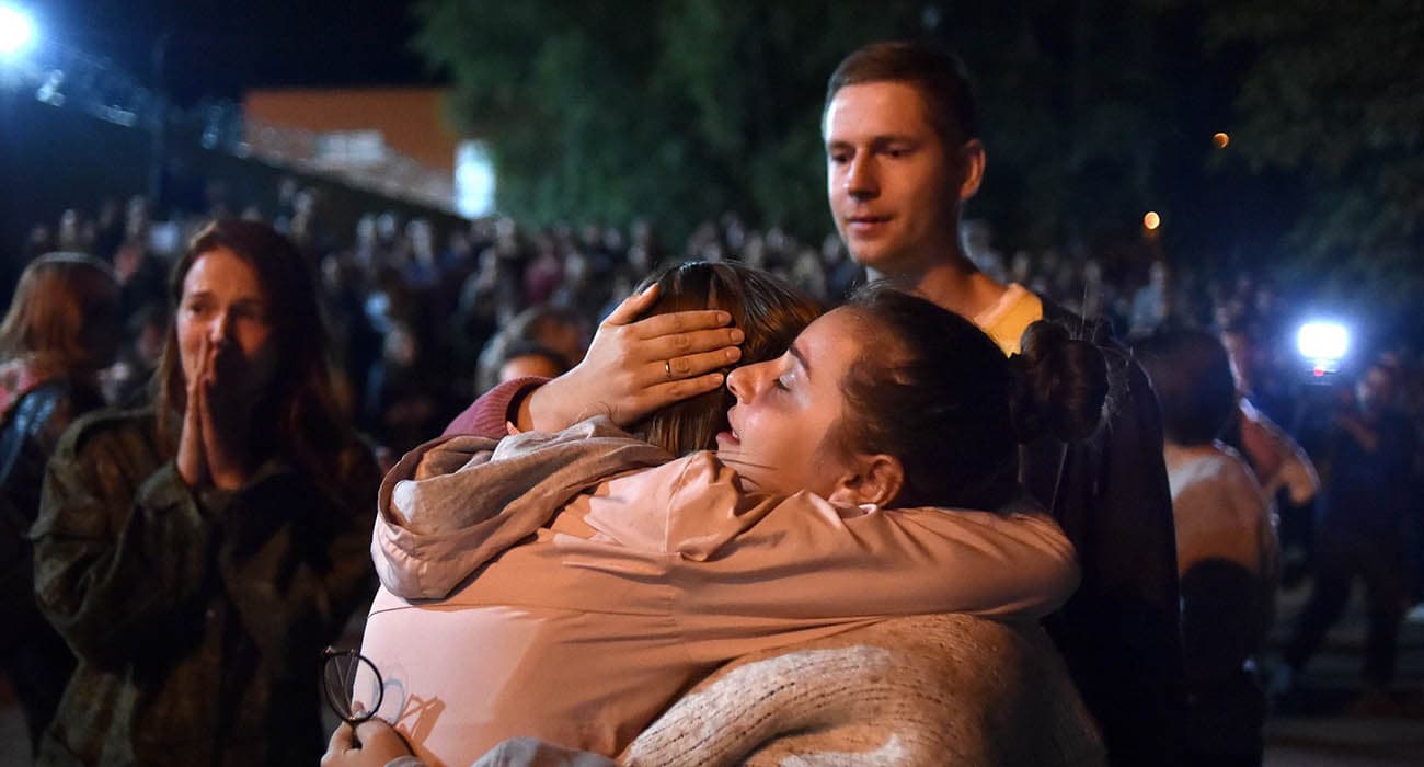 Two women hugging at an evening protest in Belarus